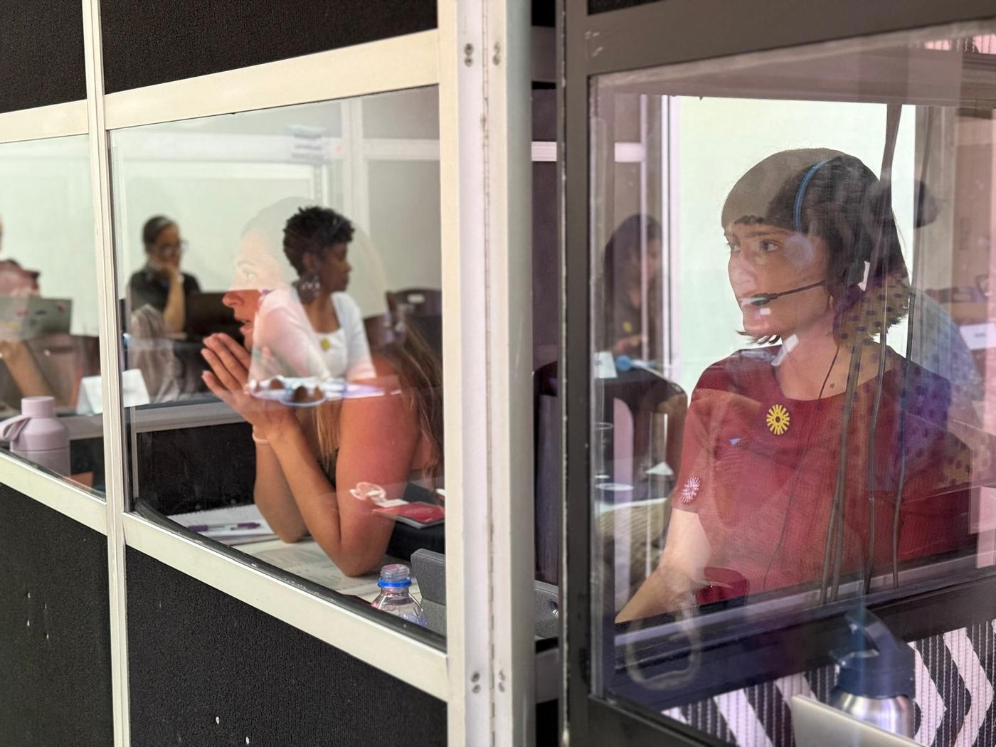 Intérpretes trabalhando em cabine de tradução simultânea